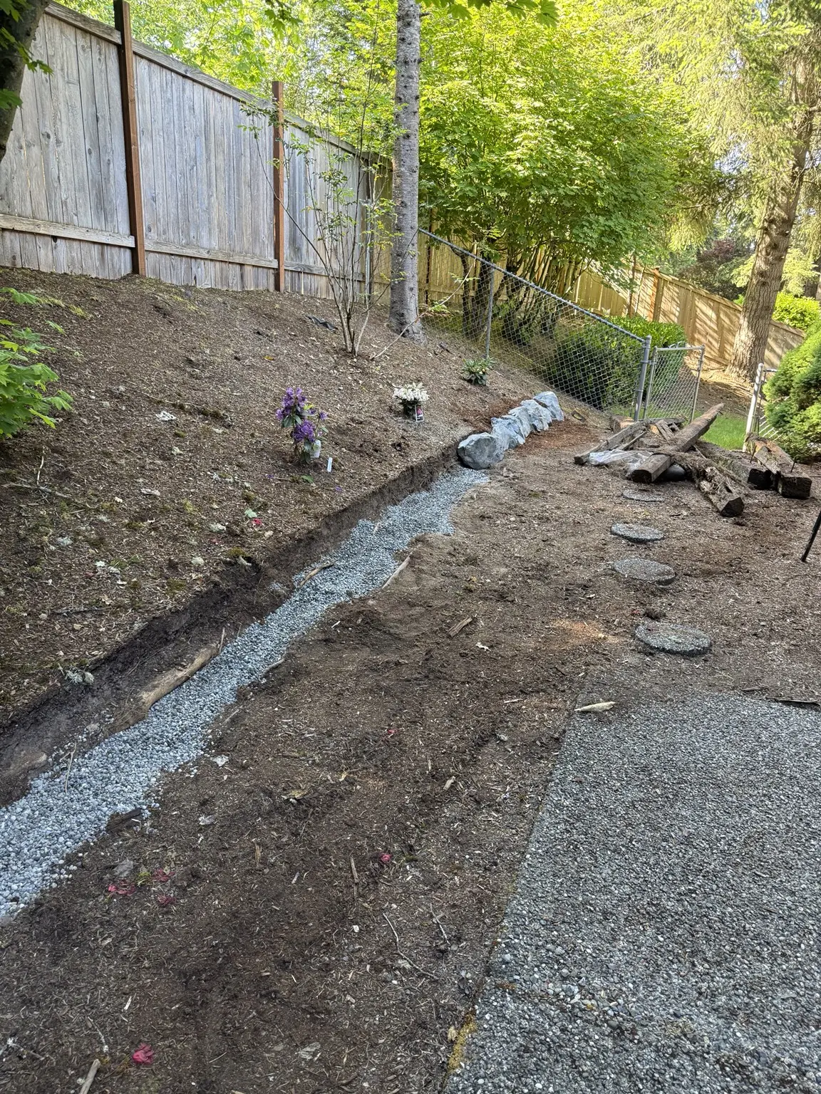 Gravel drainage and base trench prepared along the hillside entrance