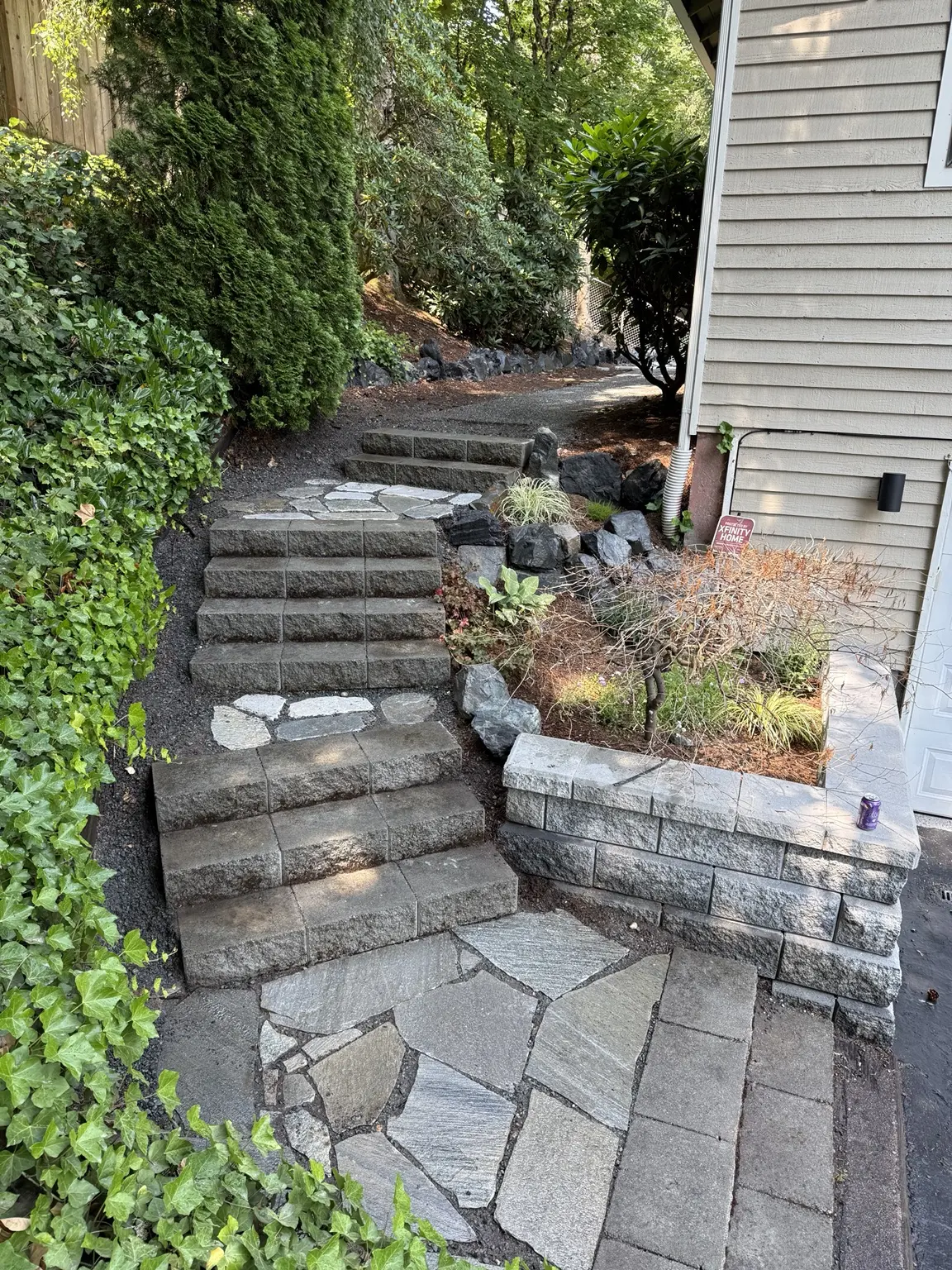 Finished home entrance with new retaining block, stone landings, steps and landscaping